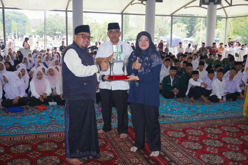 Bupati Siak, Afni Zulkifli, menyerahkan piala kepada perwakilan pemenang dalam rangkaian penutupan Hari Santri Nasional (HSN) Kabupaten Siak 2026 di Balairung Datuk Empat Suku, Kompleks Rumah Rakyat, Sabtu (24/10/2026)